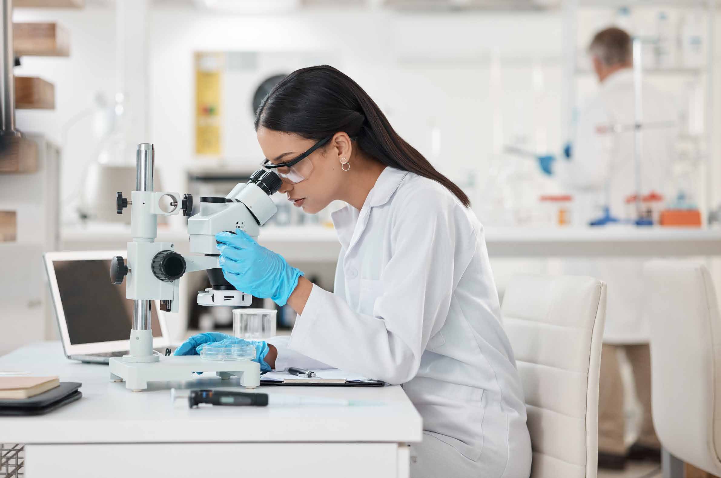 Scientist examining a sample through a microscope